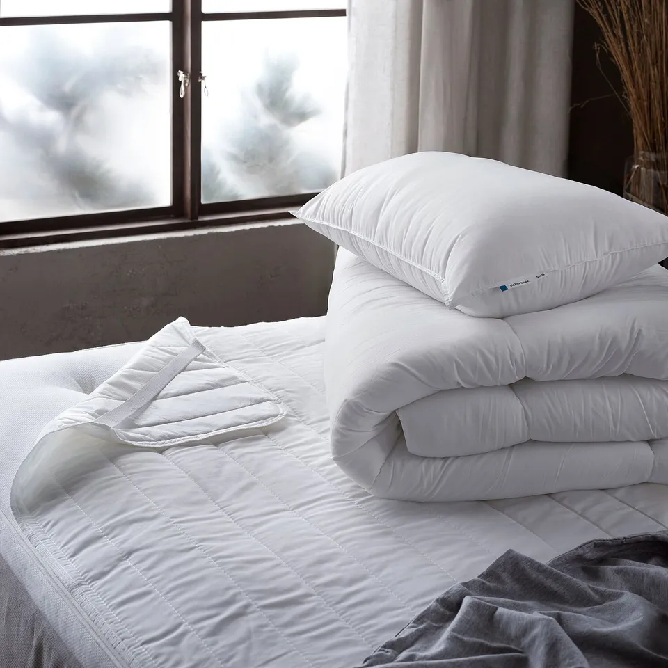 Two SMÅSPORRE pillows on bed, with blanket, window.