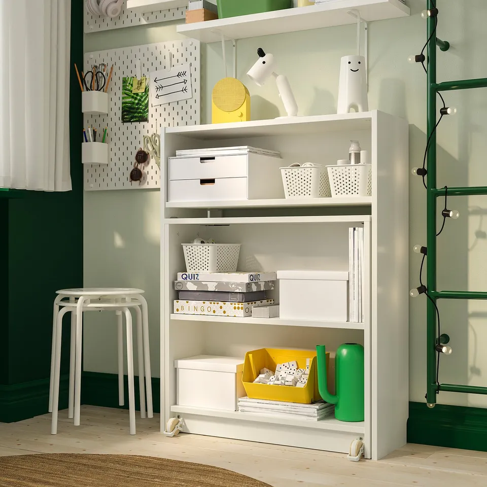 Organised shelf unit with storage boxes, books, and games; includes foldable table for workspace.