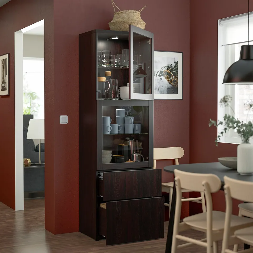 A modern glass-door cabinet displays and stores items, with drawers and adjustable shelves for flexible storage in a dining room.