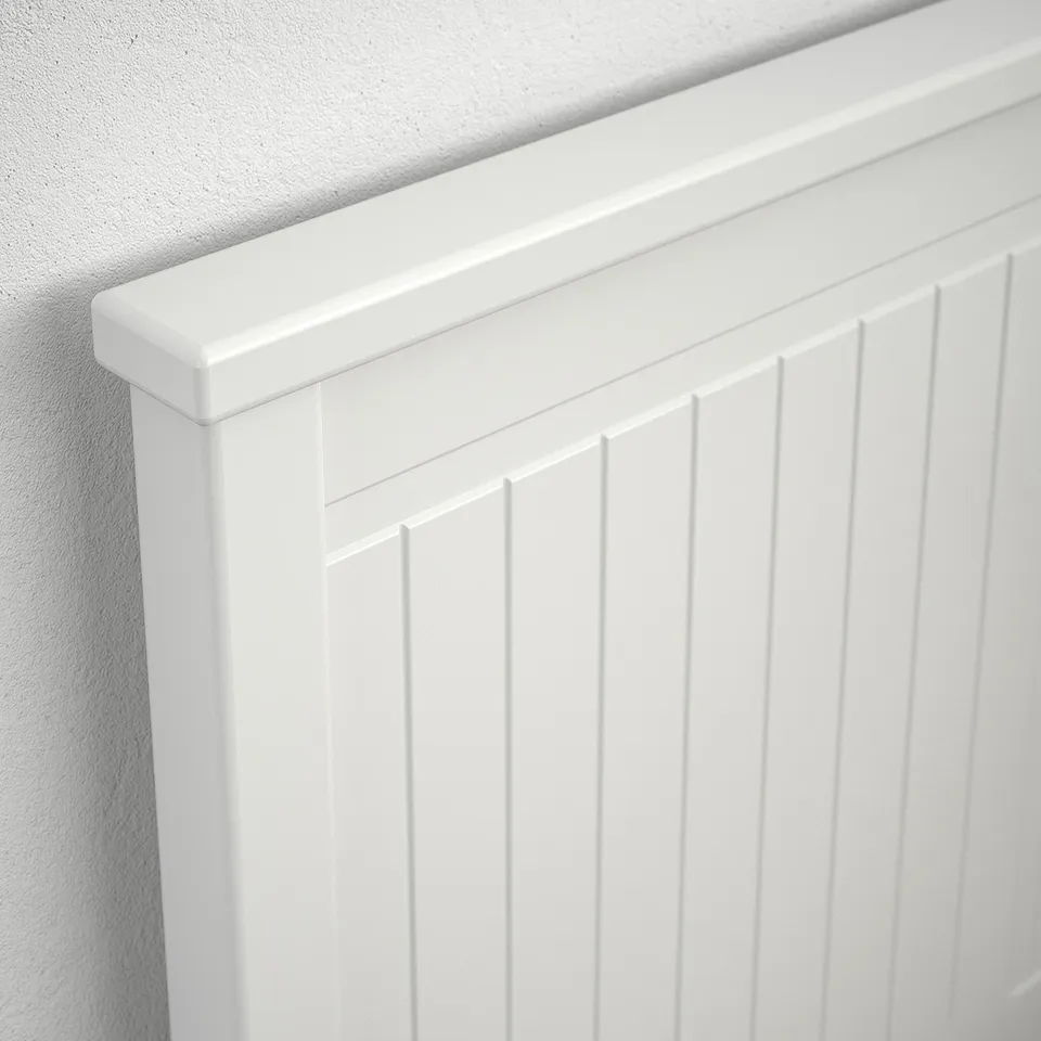 Close-up of a white, high-quality wooden headboard with vertical slats and sleek finish.