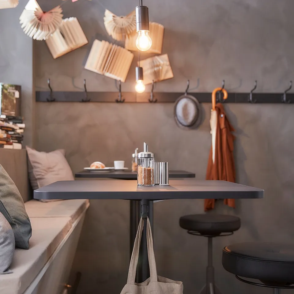 Modern kitchen with grey STENSELE bar table, bench, and stool. Beige tote underneath.