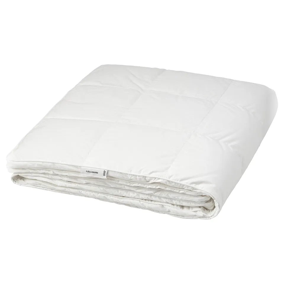 A fjällräven white down duvet folded neatly. Its soft, super-fluffy design and stitched inner walls trap warmth for a cosy sleep.