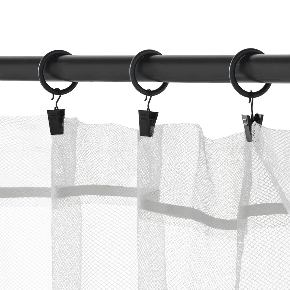 Black curtain rings with hooks hanging sheer curtains. Three rings visible, each holding fabric with hooks.