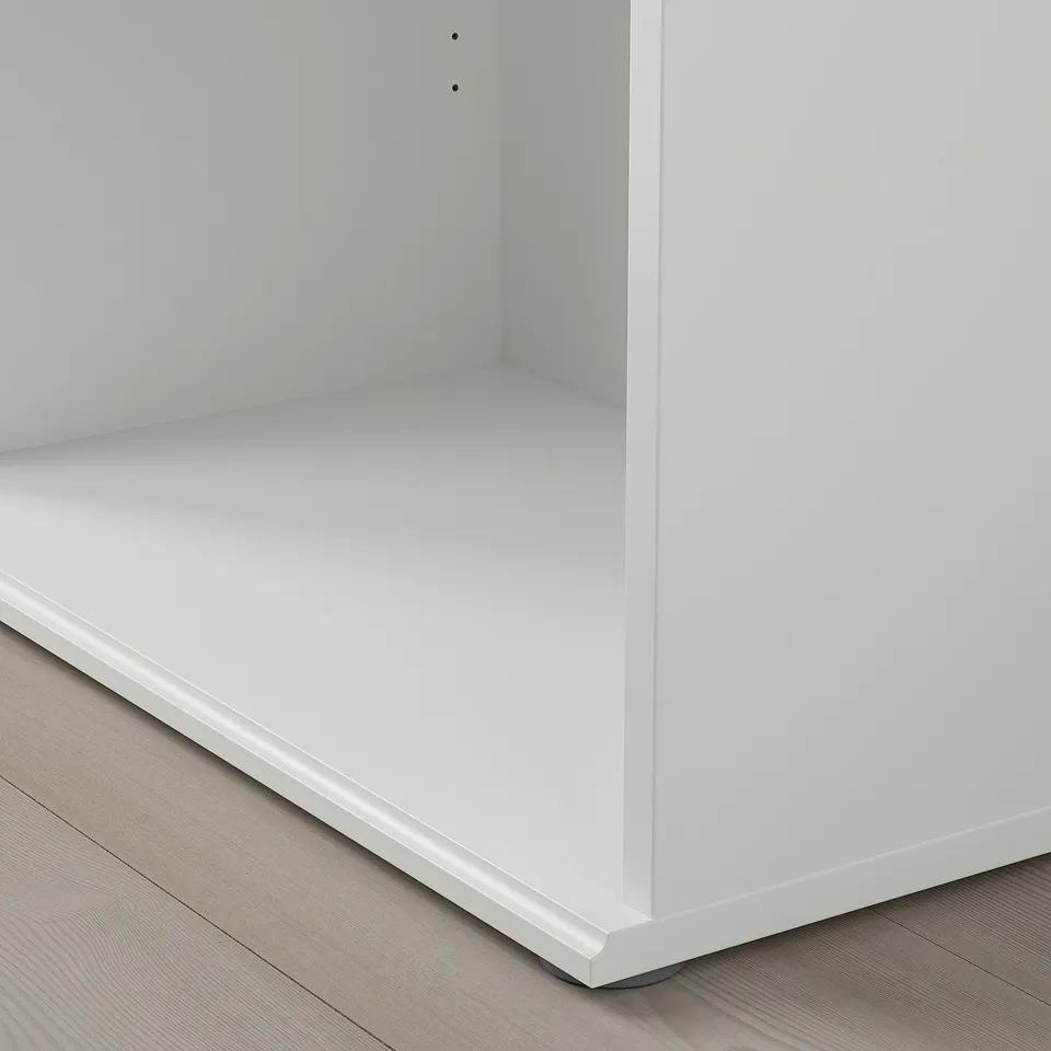 Crisp white bookcase, smooth finish, clean design, sturdy build, stands on wooden floor.