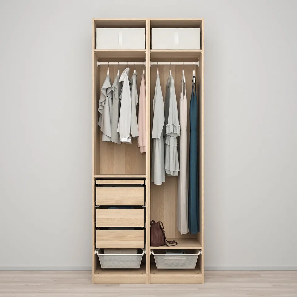 A wooden wardrobe with hanging clothes, drawers, and baskets, designed for versatile storage.