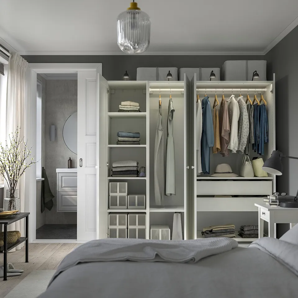 Modern bedroom with PAX wardrobe, shelves, hanging rails, and drawers, lit by pendant light.