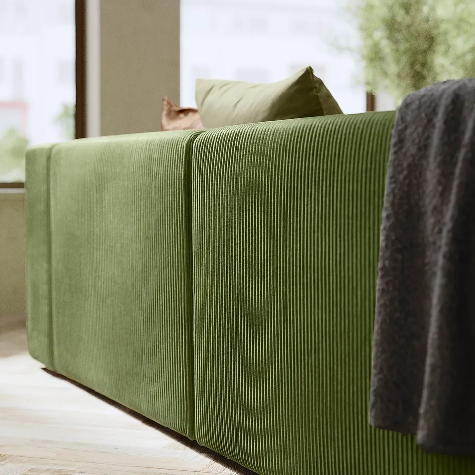 Modern green JÄTTEBO sofa, soft corduroy, with cat and pillows.