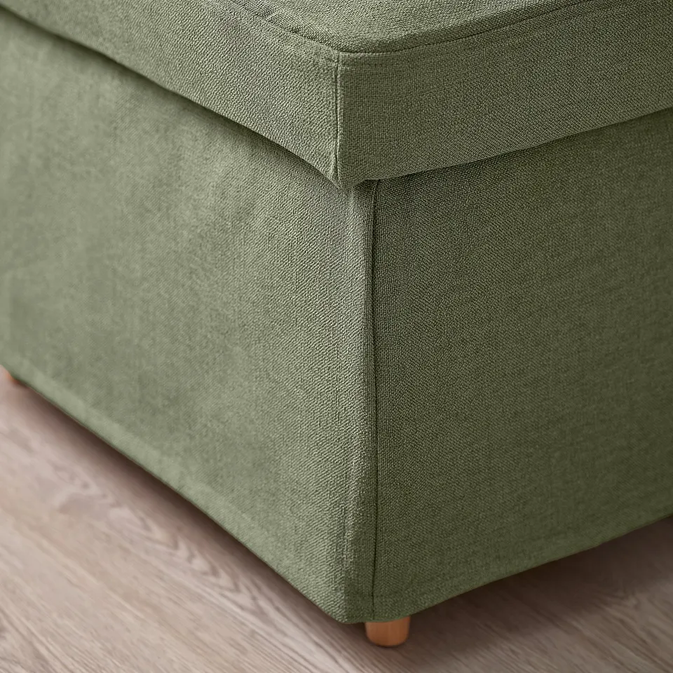 Close-up of green upholstered furniture, showcasing quality fabric and stitching.
