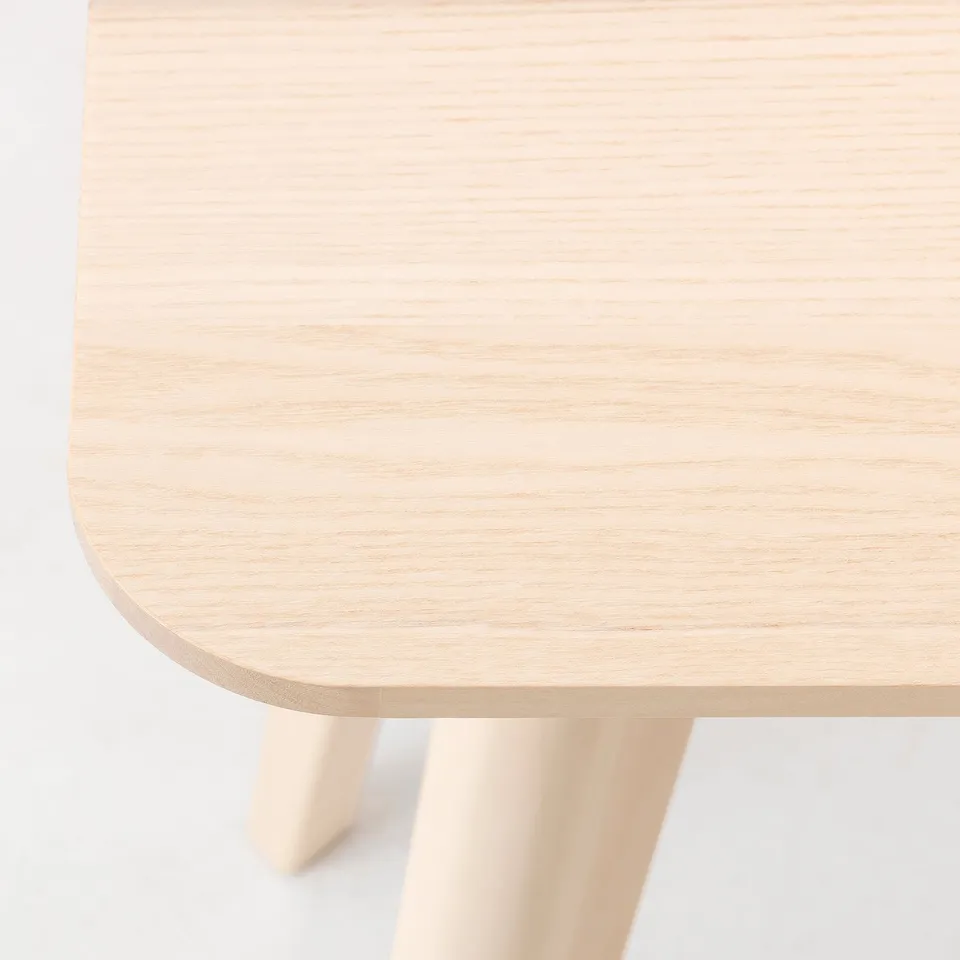Close-up of a sleek, light wood table showing smooth grain and sturdy construction.