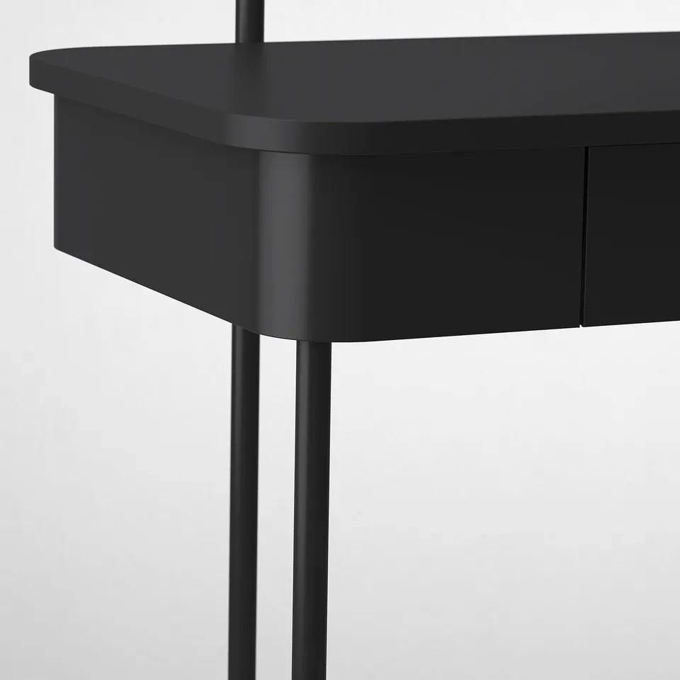 Black dressing table with metal legs, curved edges, industrial yet elegant, sturdy frame.