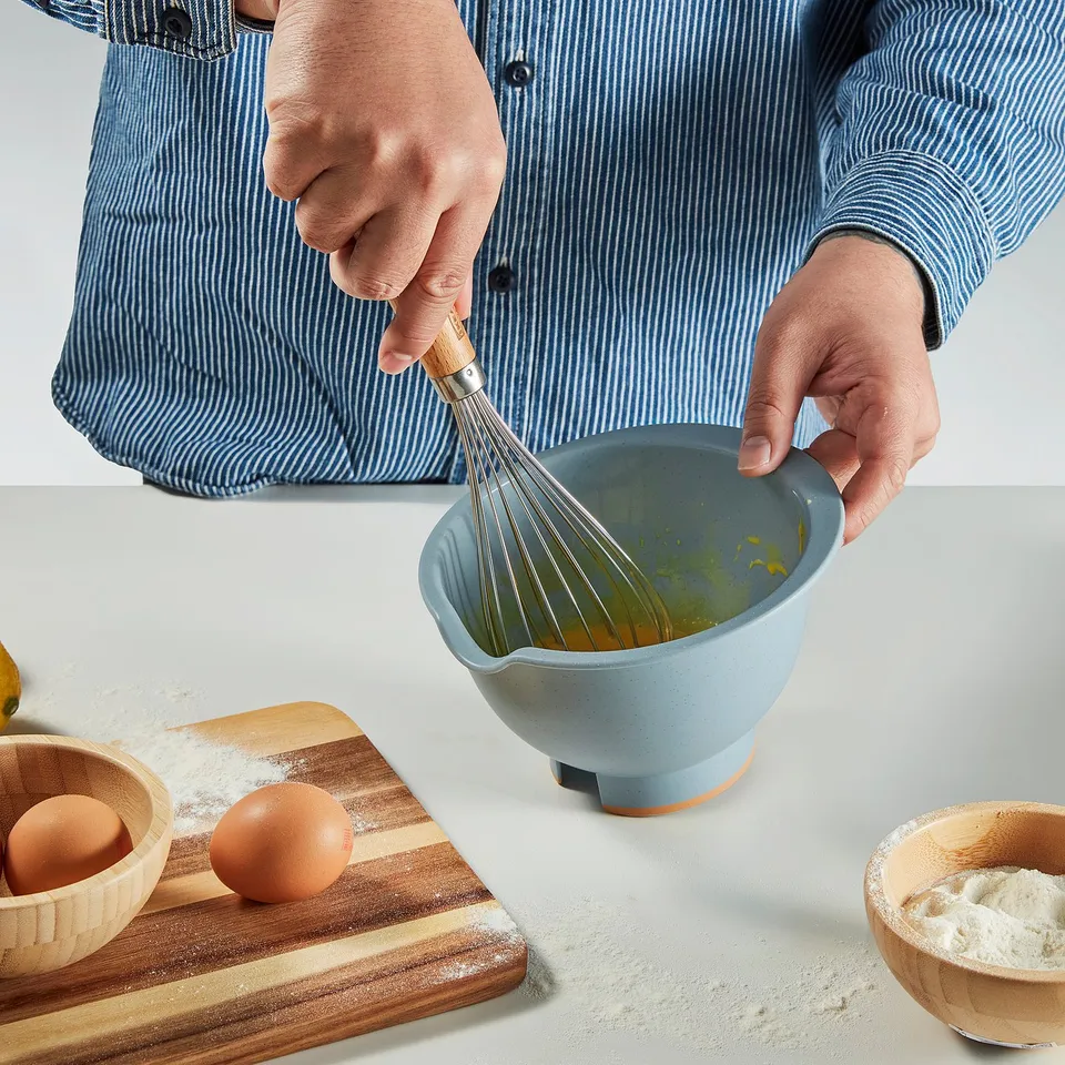Mixing ingredients with whisk in blue bowl.