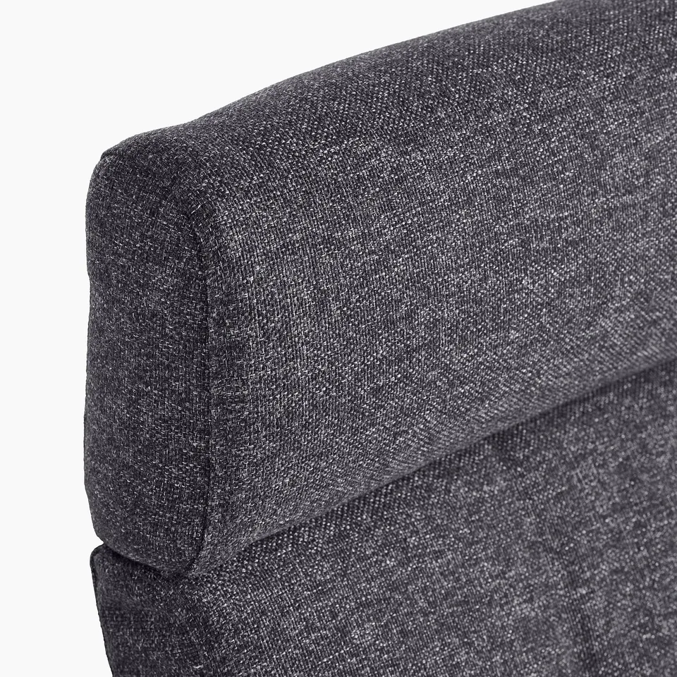 Dark grey upholstered sofa corner with plush cushioning; showcasing high-quality fabric and comfortable design.