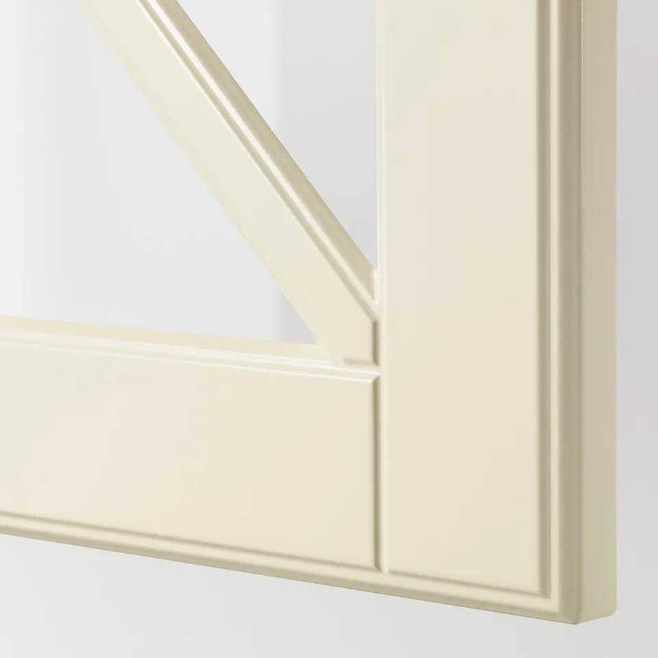 Close-up of bevelled edge on smooth off-white framed glass panel.