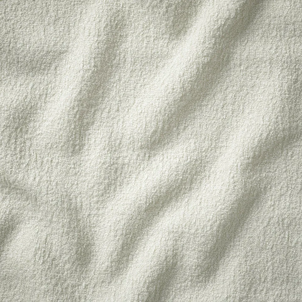 Close-up of pristine, textured white upholstery on a high-quality sofa, emphasising craftsmanship and luxury.