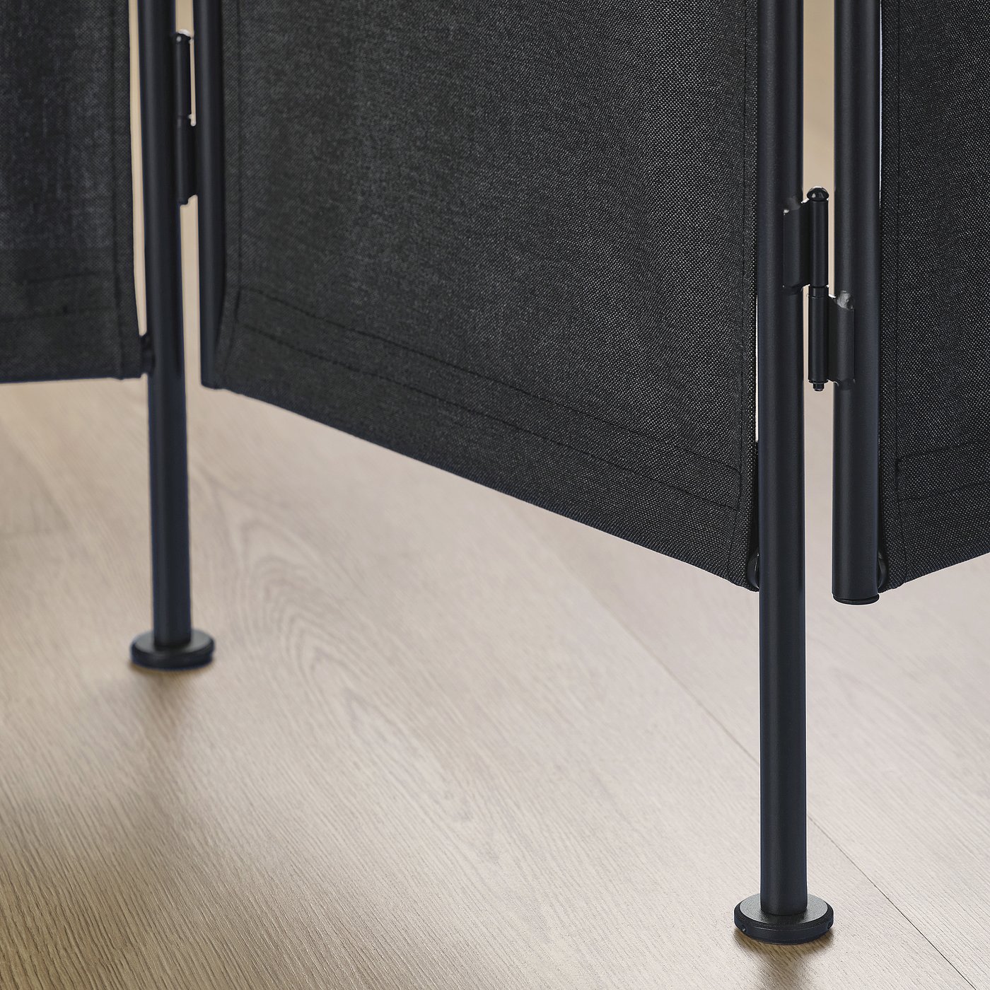 Room divider with black fabric and sturdy metal legs.