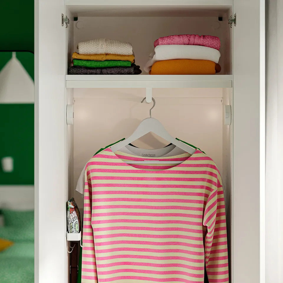 A striped pink and white shirt hanging in a wardrobe with organised shelves above.