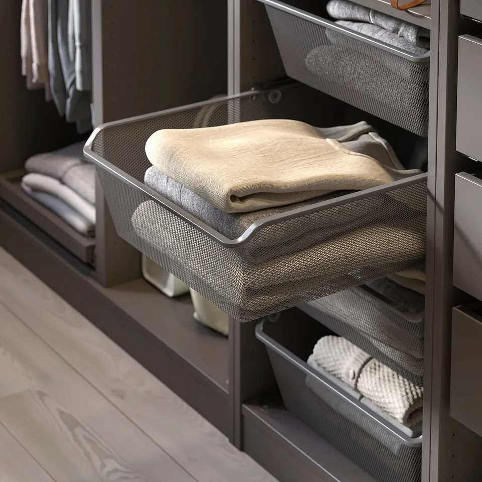 Wire basket filled with folded beige towels in organised wardrobe.