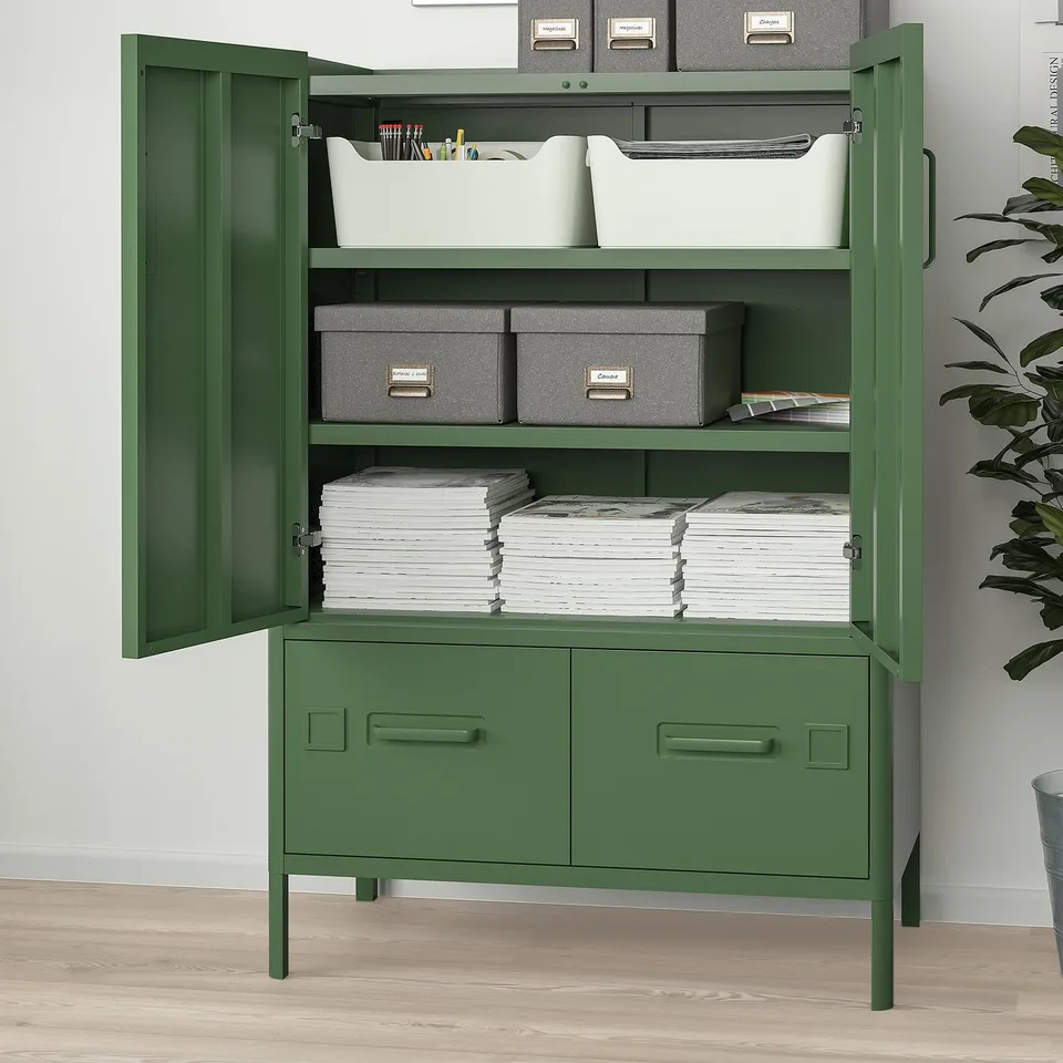 Green metal storage cabinet, open doors reveal shelves with organised supplies, stacks of paper and bins, ideal for office use.
