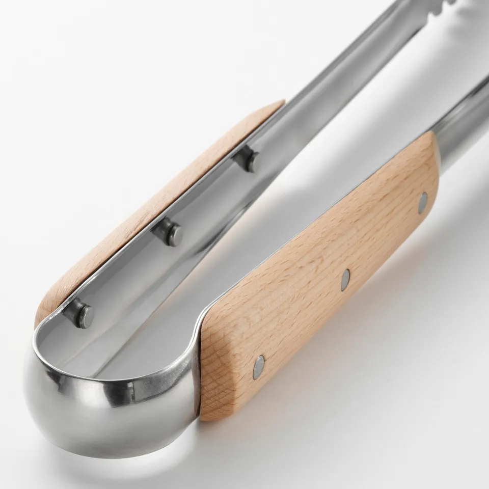 Stainless steel cooking tweezers with wooden handles, riveted for durability, resting on a white surface.