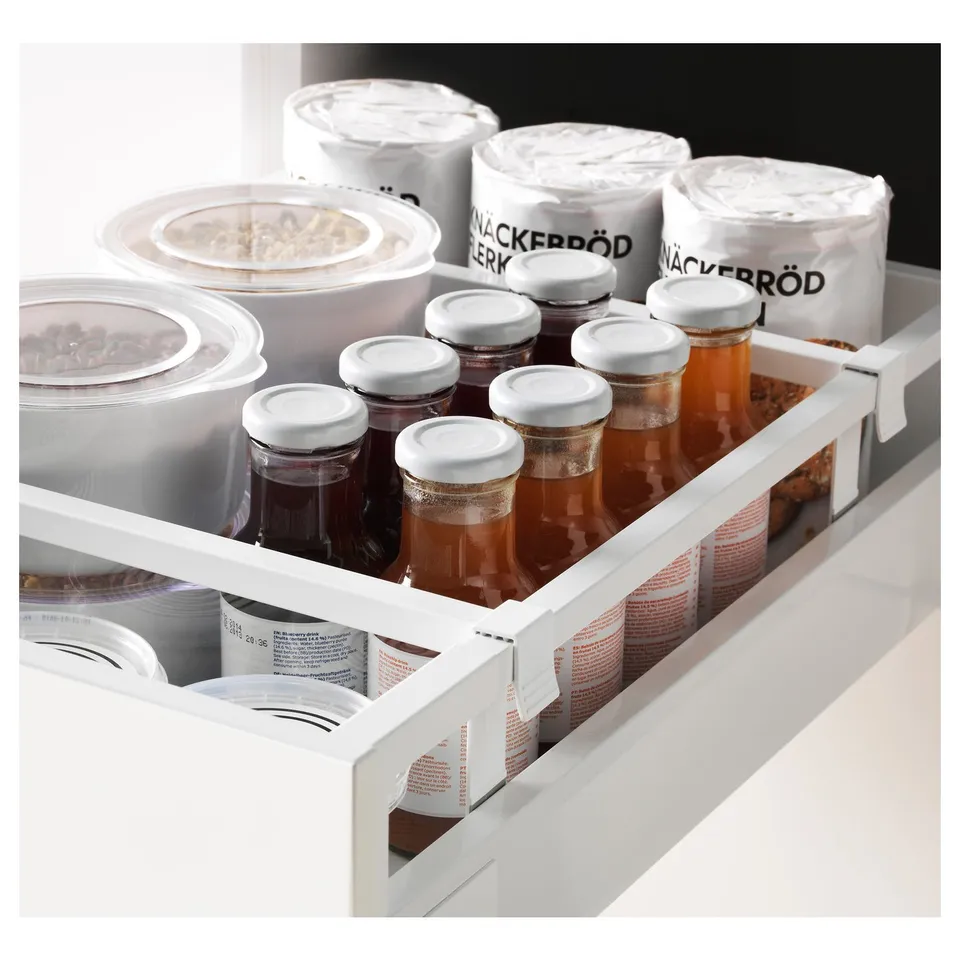 Well-organized drawer with jars and containers. Includes glass jars with white lids and labelled containers, neatly arranged.
