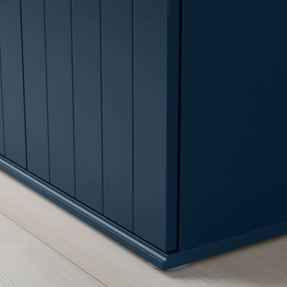 Close-up view of SKRUVBY cabinets sturdy, dark blue, grooved panel with polished edge on wooden floor.