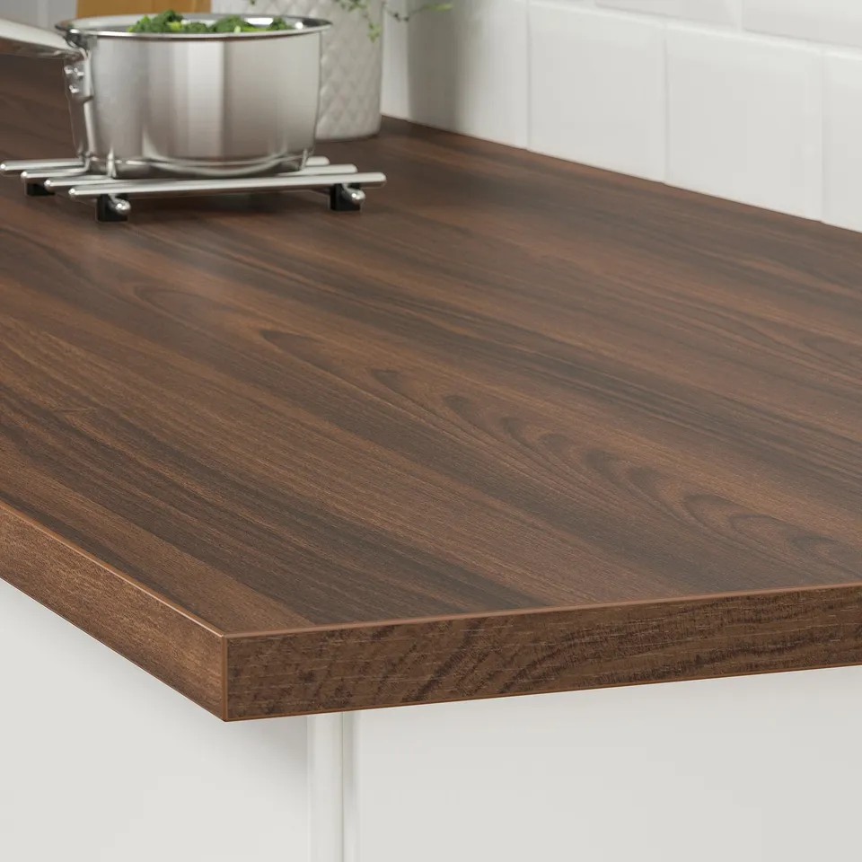 Dark wooden countertop with a metal bowl and trivet on it. Easy to clean and durable for kitchen use.