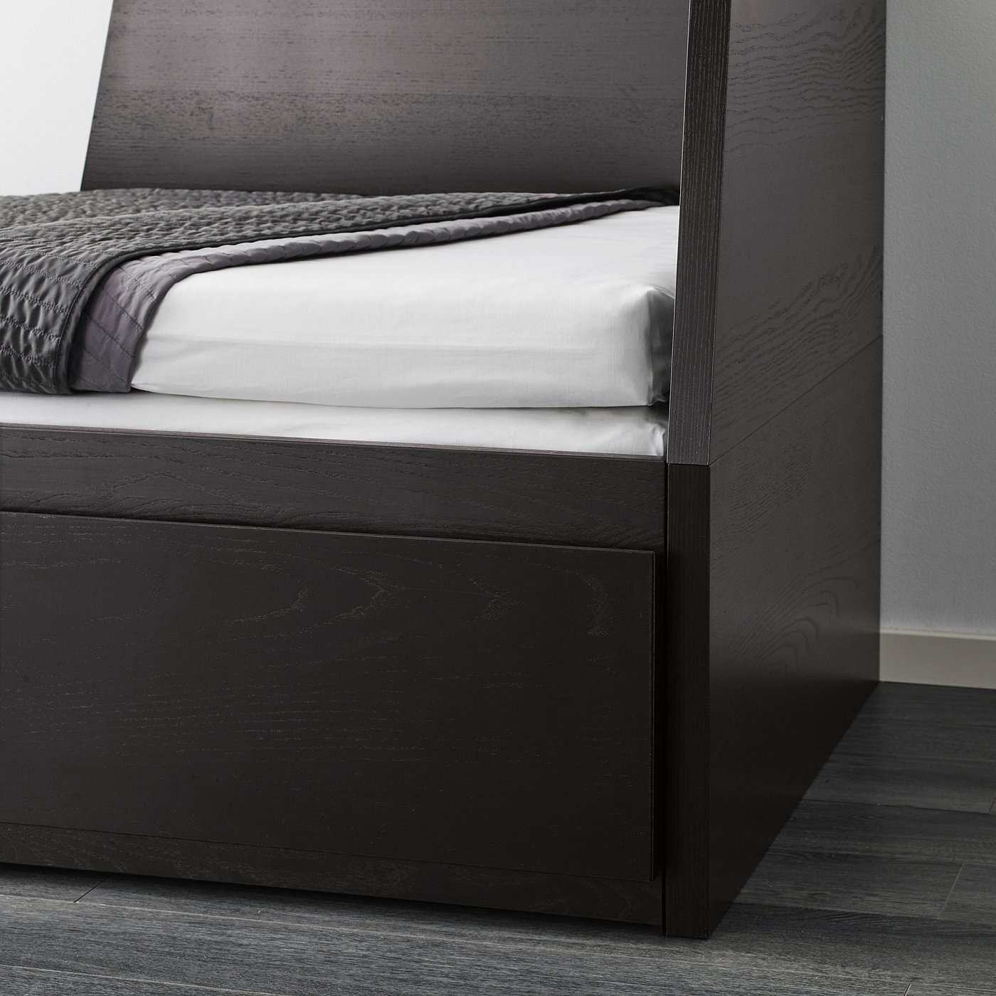 Black day-bed with two drawers for storage, showing a bed base with crisp white linens.