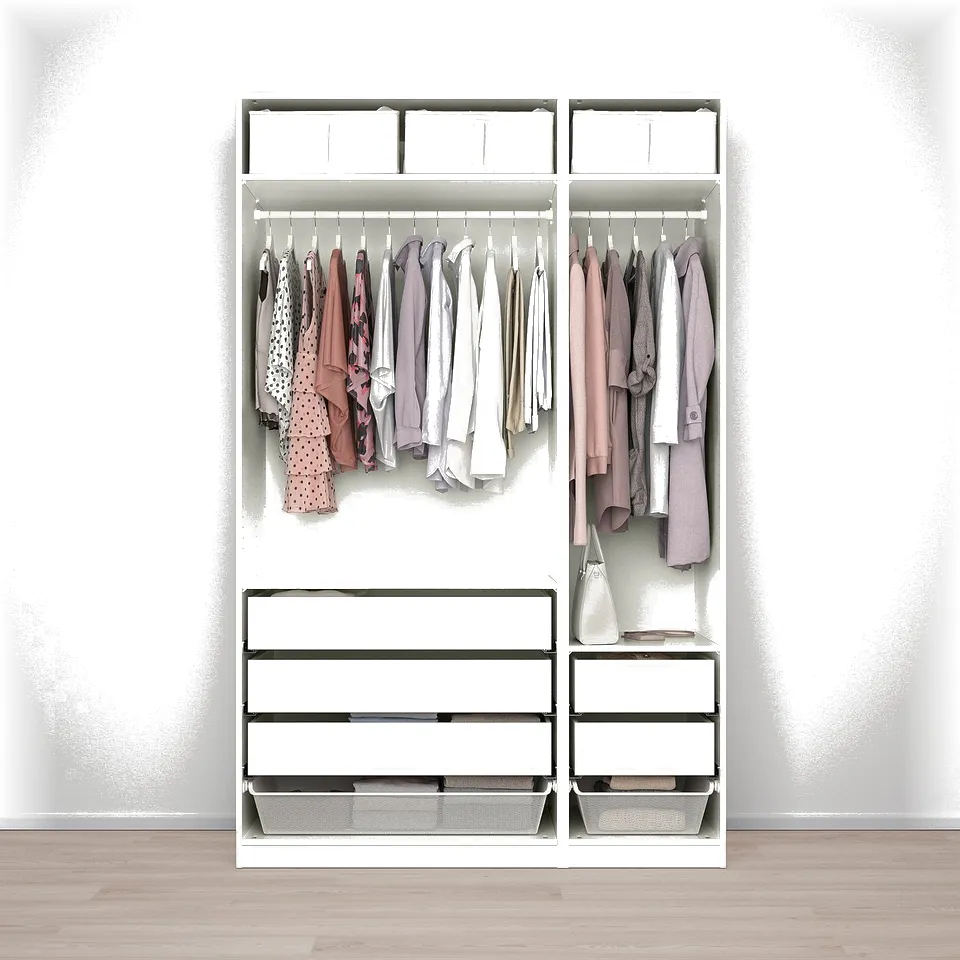 Modern open wardrobe displaying clothes, with drawers at the bottom, on wooden floor.