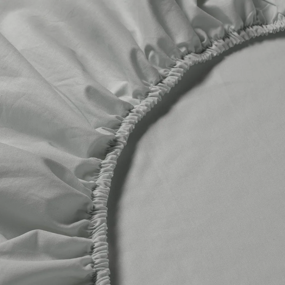 Close-up of a soft, pure cotton fitted sheet showcasing its elastic edging, highlighting its quality and comfort.