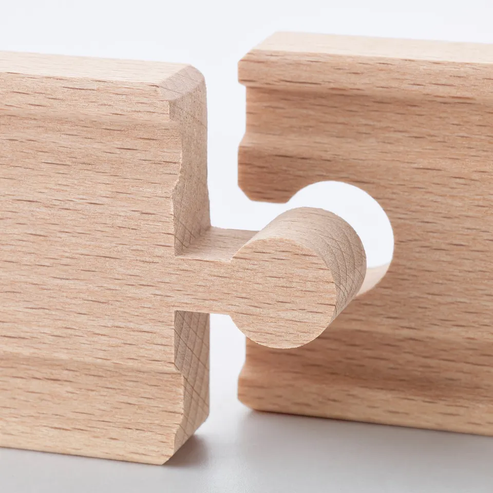 Wooden train track pieces, carefully crafted with smooth edges and fine grain detail, neatly arranged on a white surface.