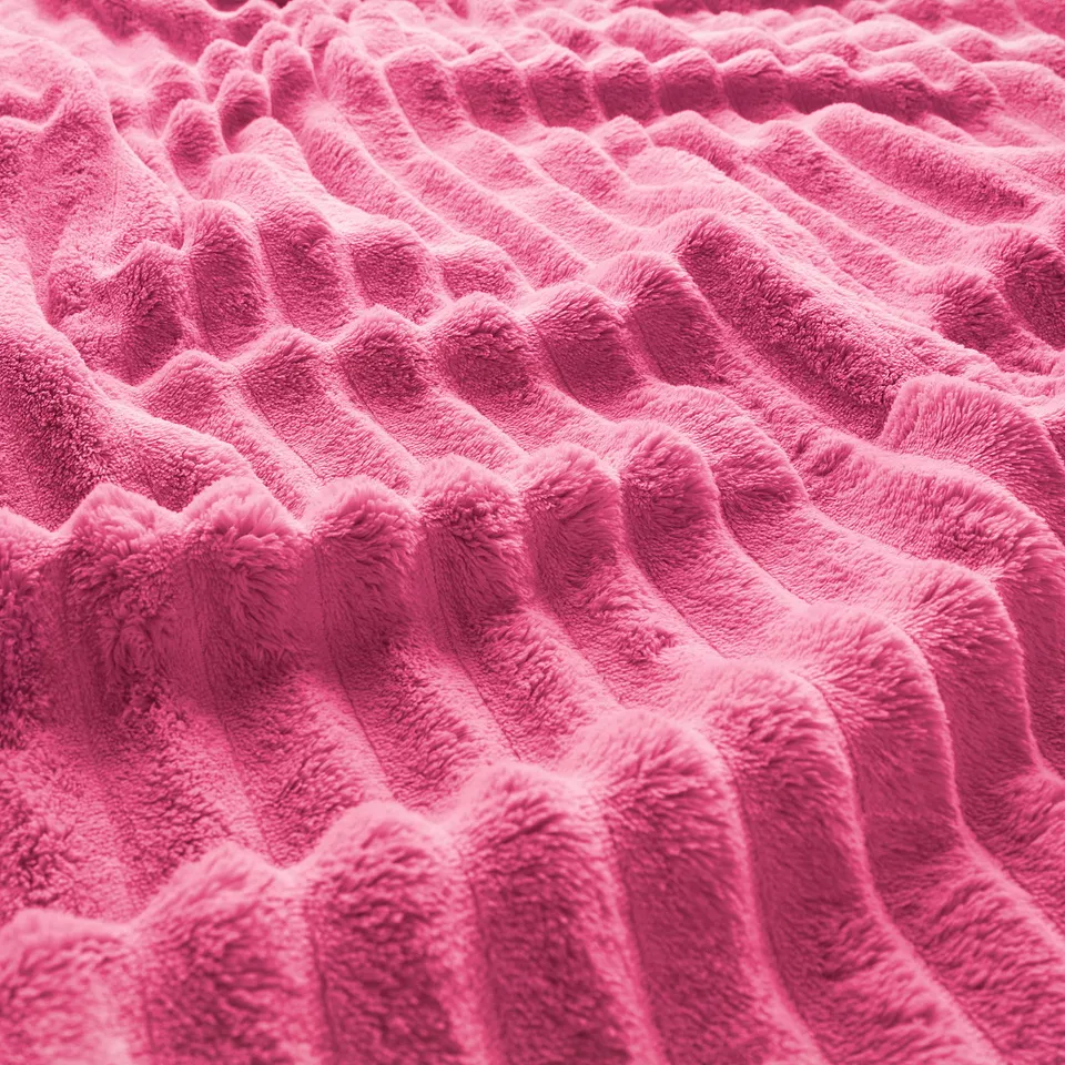 Bright pink soft fleece bedspread, close-up showing plush texture and warm, cosy material.