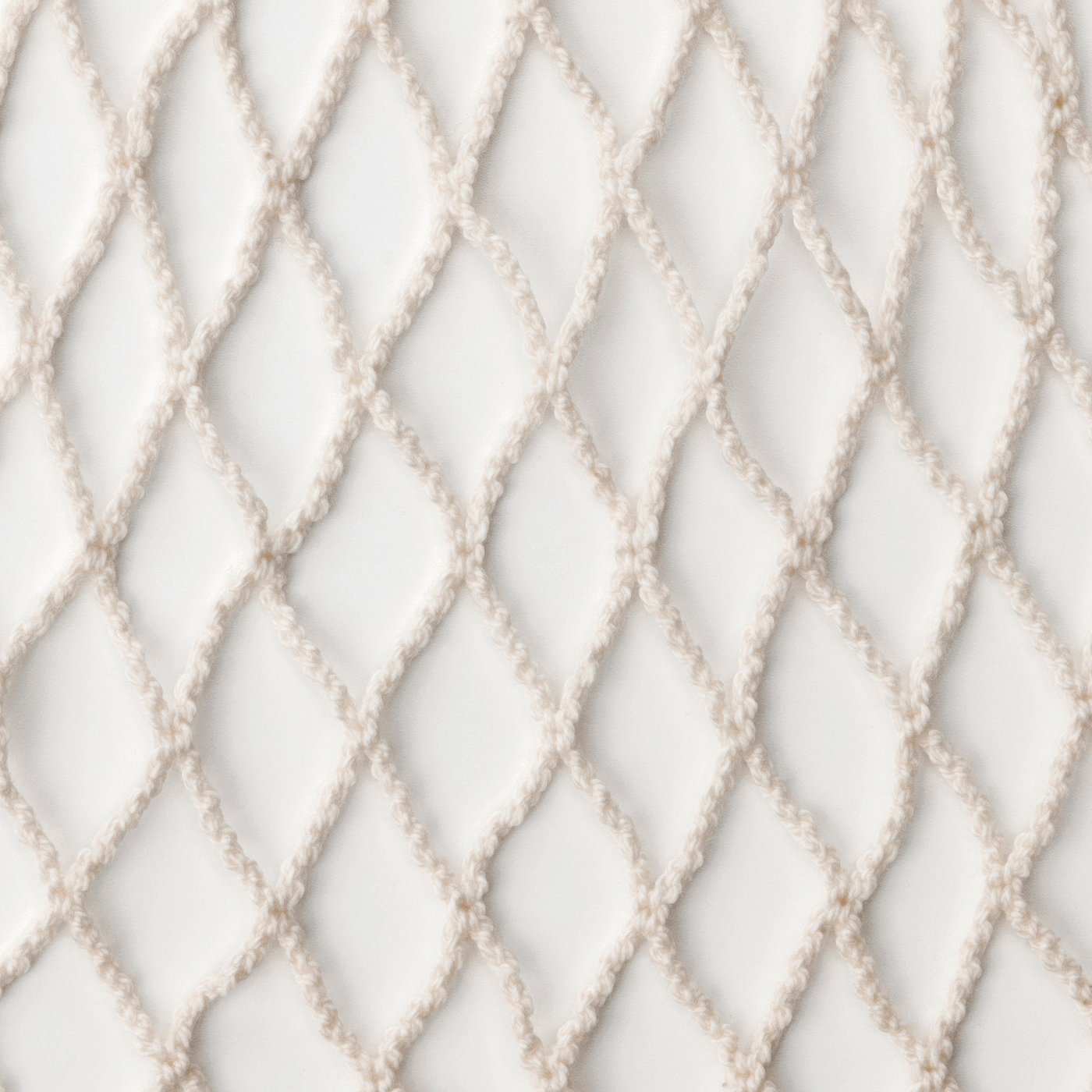 Clean white cotton net bag, finely woven with diamond patterns, ideal for fruit storage.