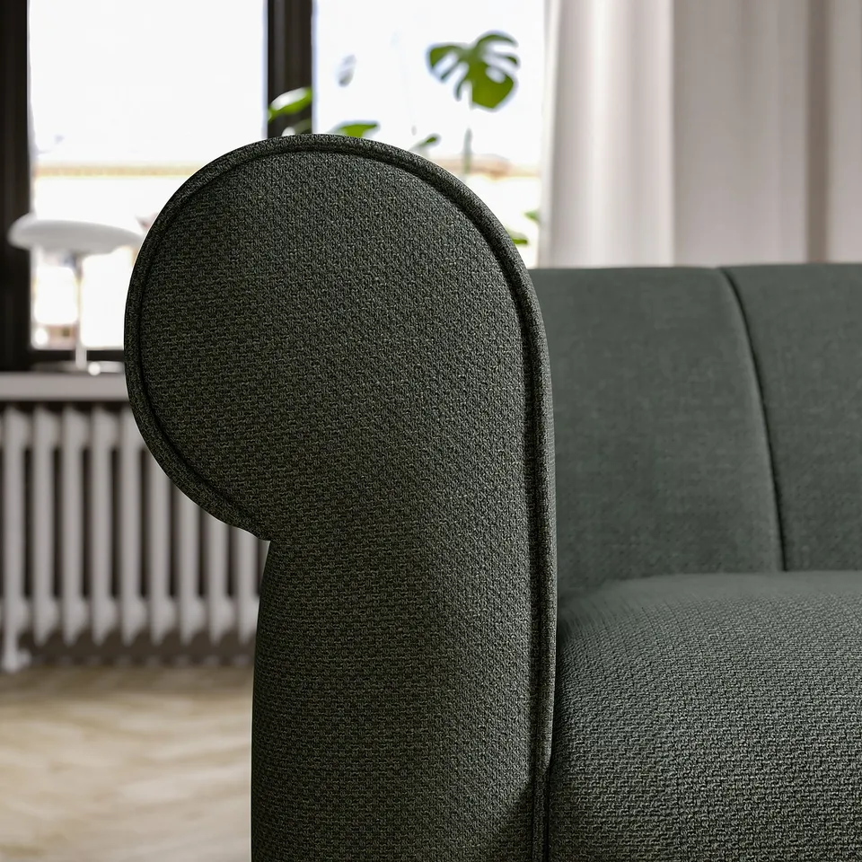 A green VISKAFORS armchair, deep seat, rounded shapes, soft fabric cover.