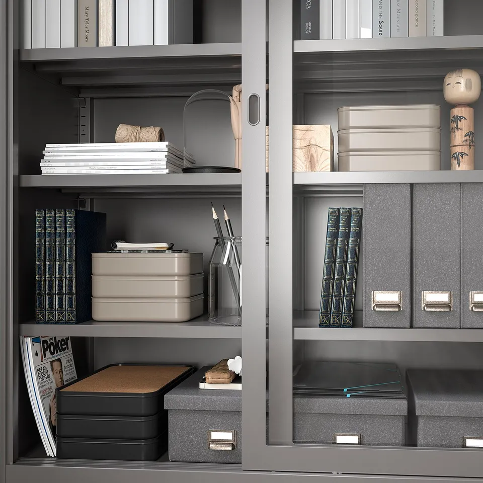Organised shelves with grey HARVMATTA boxes, storing papers and office supplies neatly.