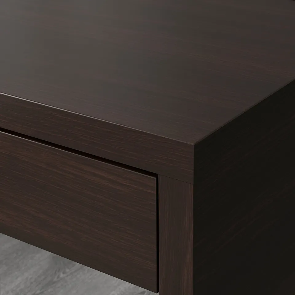 Dark wooden desk corner, sleek finish, smooth edges, cable management hole visible, showcasing quality craftsmanship.