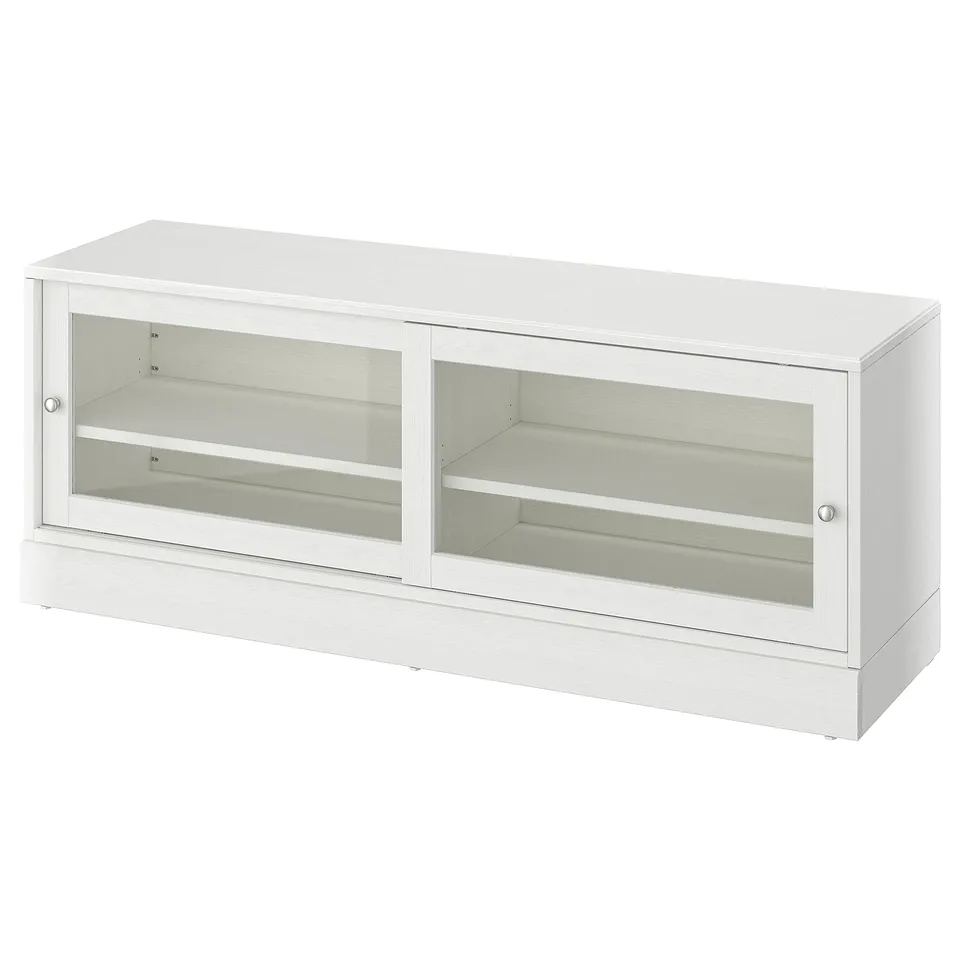 A white HAVSTA tv bench with glass doors, displaying a rustic pine wood design. It a rectangular shape with sliding doors for cable management.