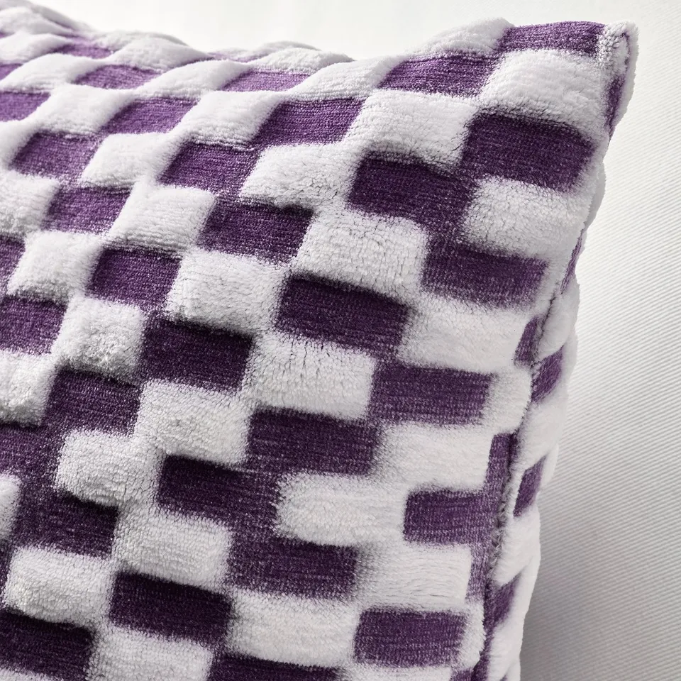 Soft, textured cushion with purple and white pixel patterns.