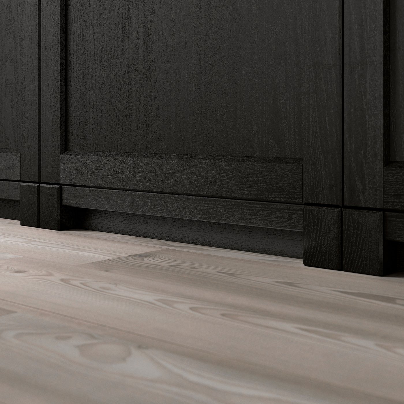 Black wooden furniture legs on light wooden floor.