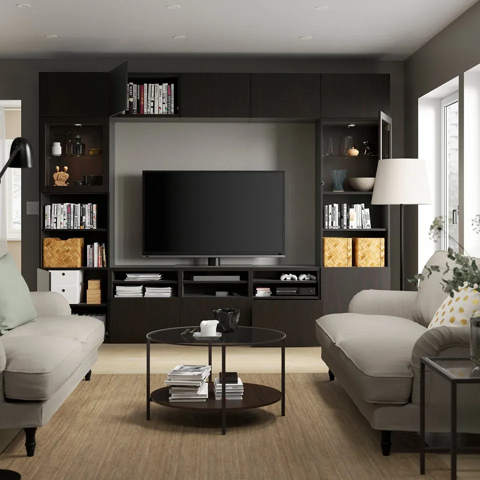 Modern living room with BESTÅ tv unit, flat screen, adjustable shelves, and light grey sofas flanking a round coffee table.