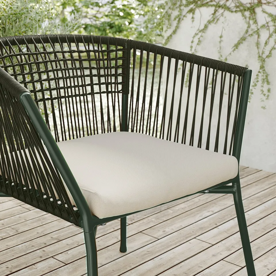 Black rope outdoor patio chair with beige cushion.