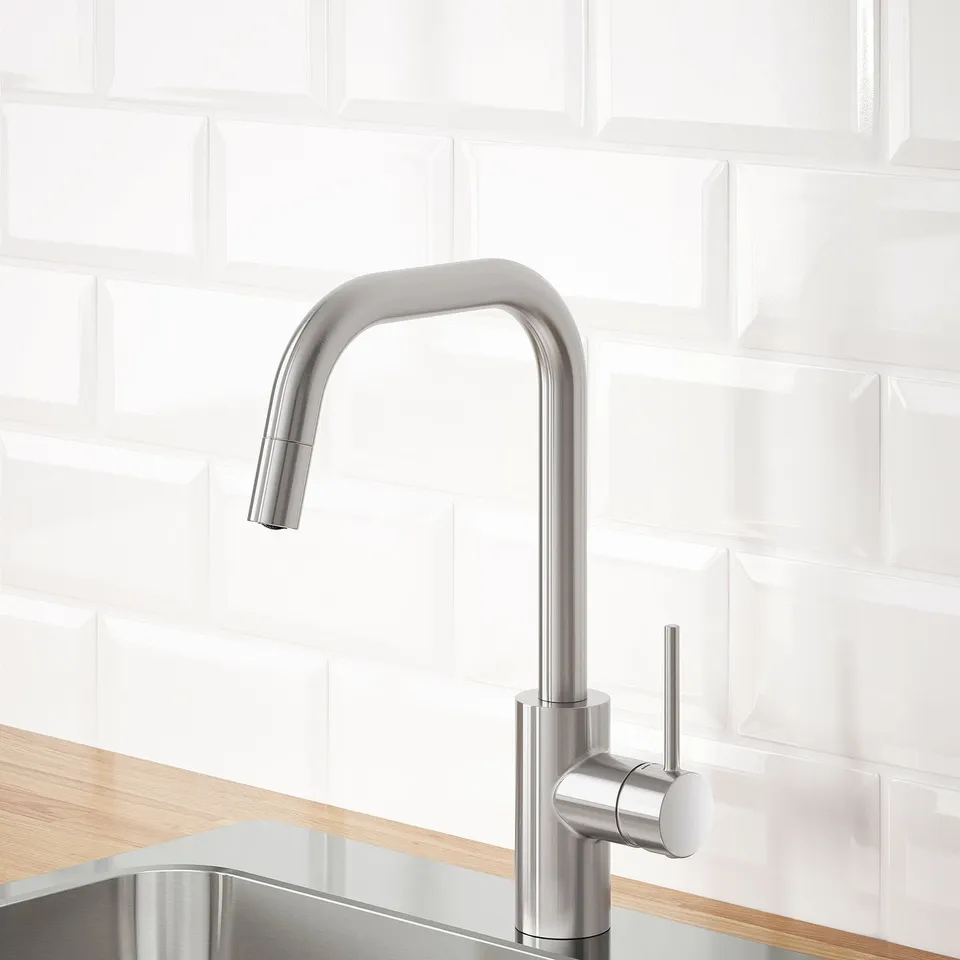 Stainless steel kitchen tap with pull-out spout on wooden counter.