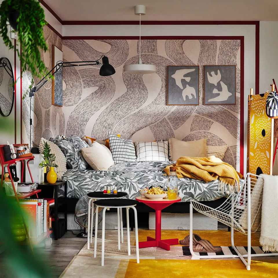 Modern bedroom with BROKDRACENA duvet, floral pattern, yellow & grey, abstract art, red accents.