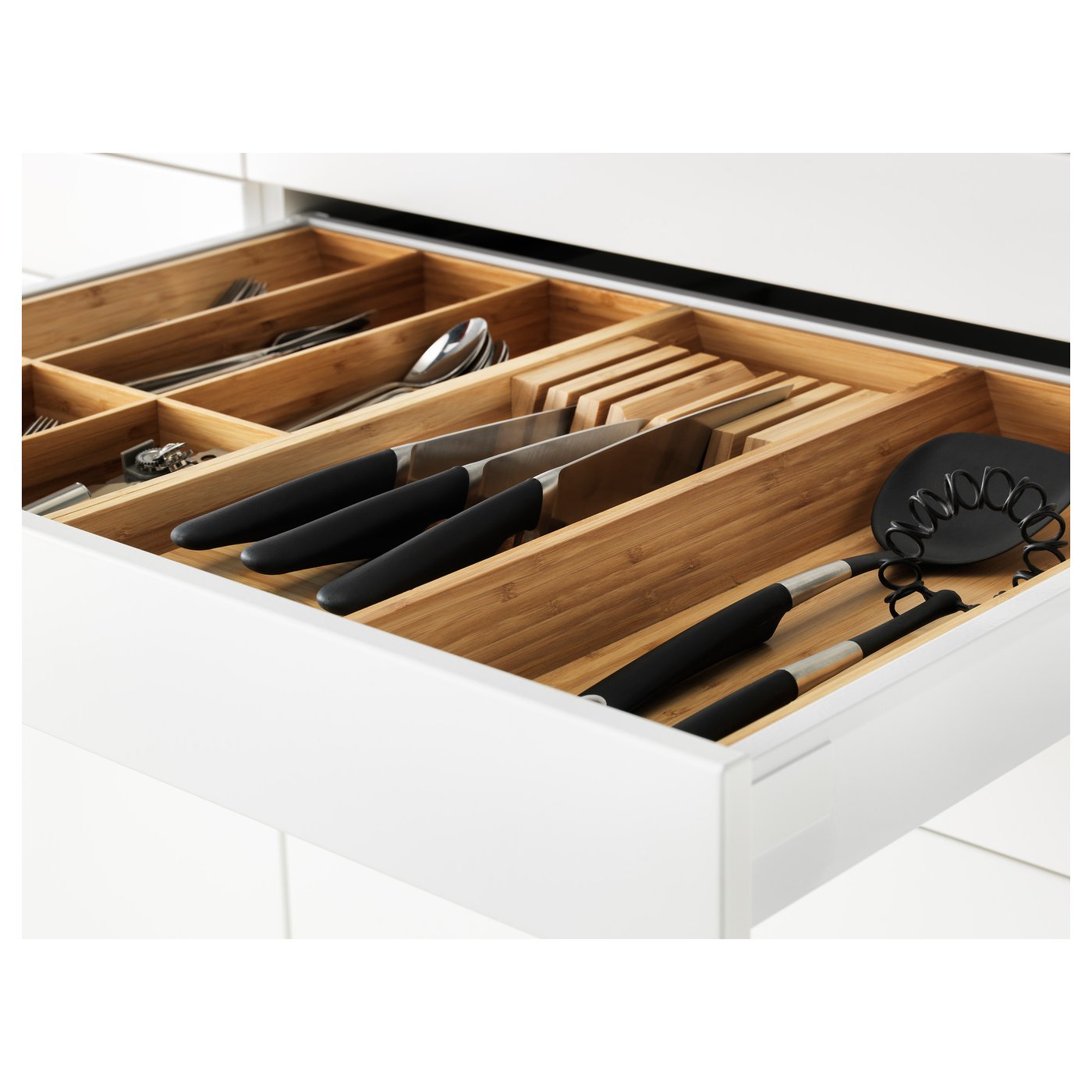 Open kitchen drawer with wooden divider trays holding knives, utensils, and cutting boards. Part of METOD system.