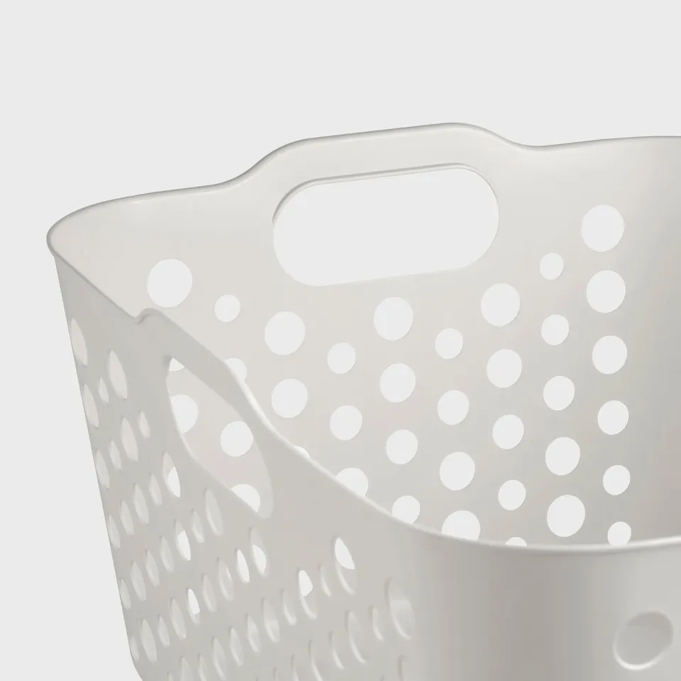White perforated laundry basket with sturdy handles, designed for durability and ventilation.