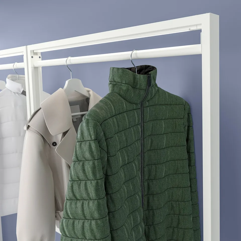 Green jacket hangs on a white clothes rail, with grey and white coats. Modern, organised storage display.