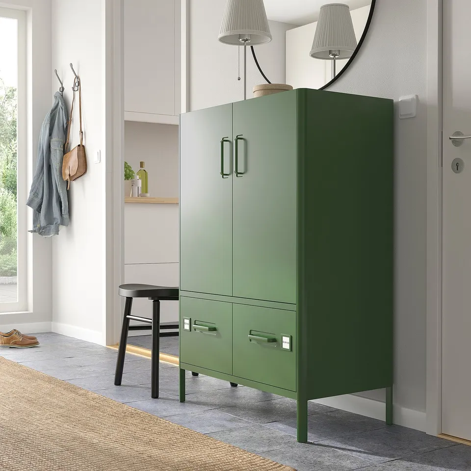 Modern entryway with tall green IDÅSEN cabinet, black stool, coat hooks, and floor lamp.