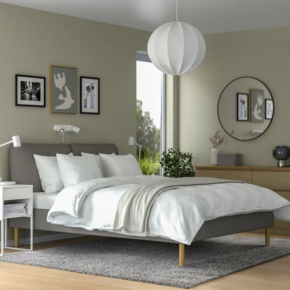 Modern bedroom with grey ÄRENDE rug, matching bed, and white pendant light. Minimalist decor.