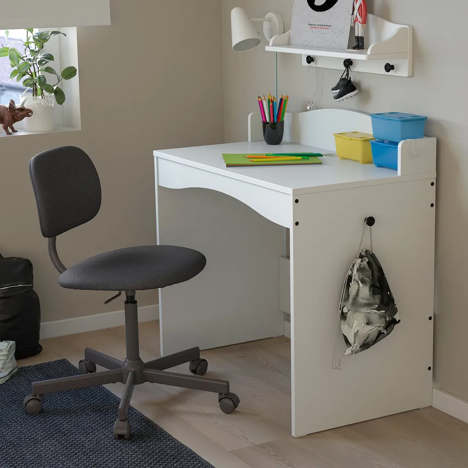 Small kids desk, white SMÅGÖRA, corner study area. Includes grey chair, pencil holder, bright storage boxes, white shelves.
