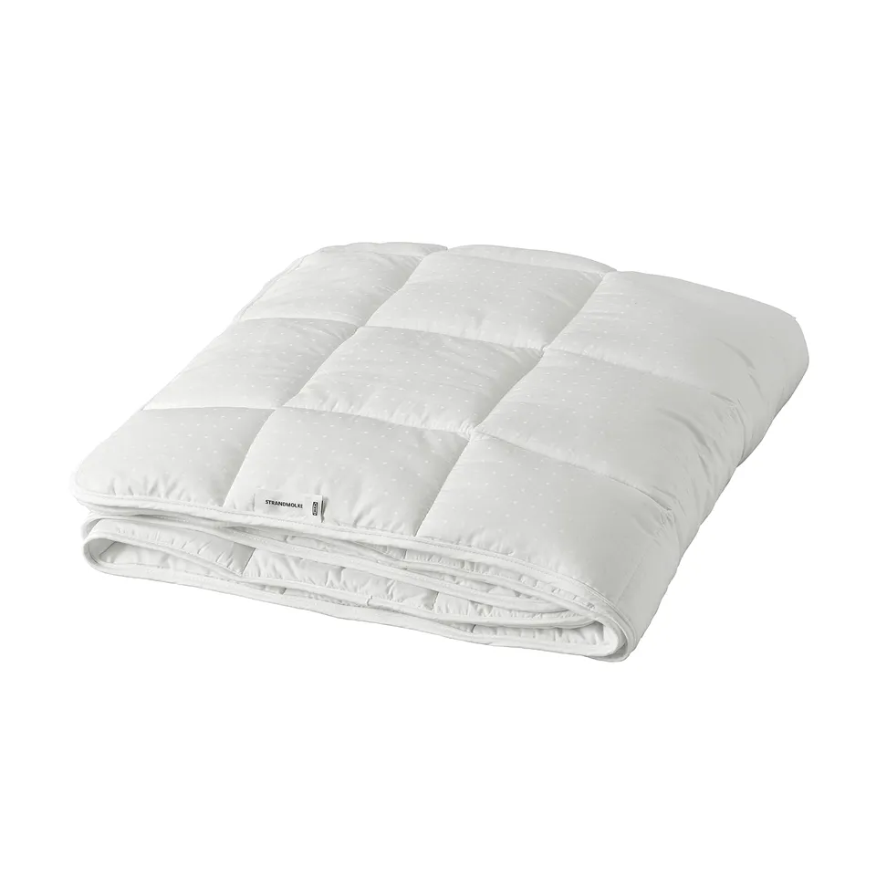 A white STRANDMOLKE duvet, rectangular in shape, with a soft, woven cotton cover and a fluffy polyester filling. Its ideal for warmth and comfort.