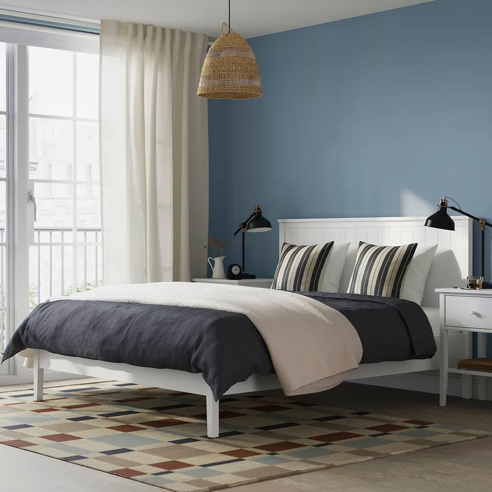 Blue bedroom with white GULLABERG bed, rug, lamp, & nightstands.